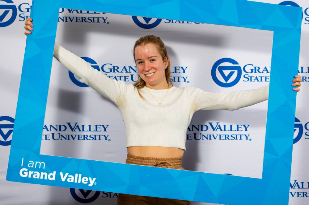 individuals smiling holding i am grand valley sign